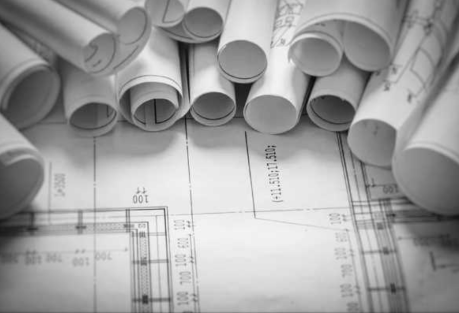 a group of rolled up blueprints from Beacon Home Design that represent their portfolio library for custom homes